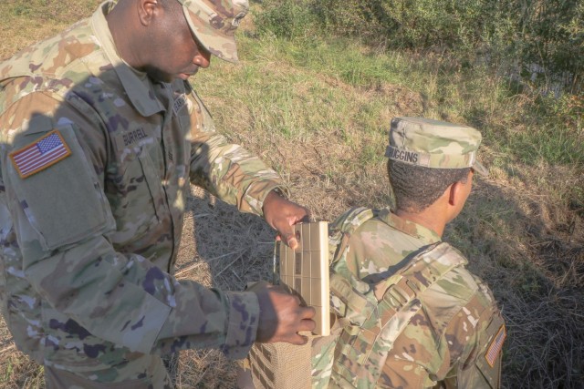 Army C5ISR Center enlisted advisers Sgt. Corey Burrell (left) and Sgt. 1st Class Patrick Huggins demonstrate the Soldier Wearable Power Generator at Aberdeen Proving Ground, Maryland, on Oct. 27, 2021.