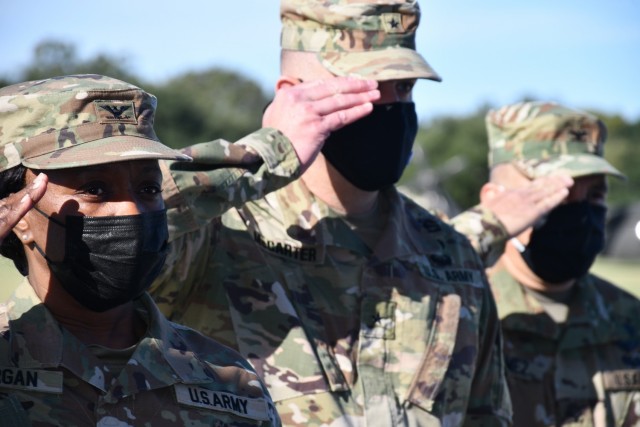 From left to right Col Sarolyn Morgan, incoming commander of the  3rd Medical Training Brigade, Brig. Gen. Jeffrey McCarter, Army Reserve Medical Command deputy commanding general, and Col. Carlos Tamez, outgoing 3rd MTB commander, rendor honors during the playing of the National Anthem at the 3rd MTB change of Command ceremony.