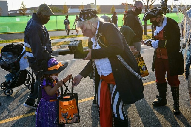 Volunteer pirates stop looting to hand out candy to during the installation's annual Trunk or Treat extravaganza Oct. 30, 2021. Volunteers decorated their trunks with different themes and dressed in matching costumes to hand out candy to families. (U.S. Army photo by Spc. Brooke Davis)