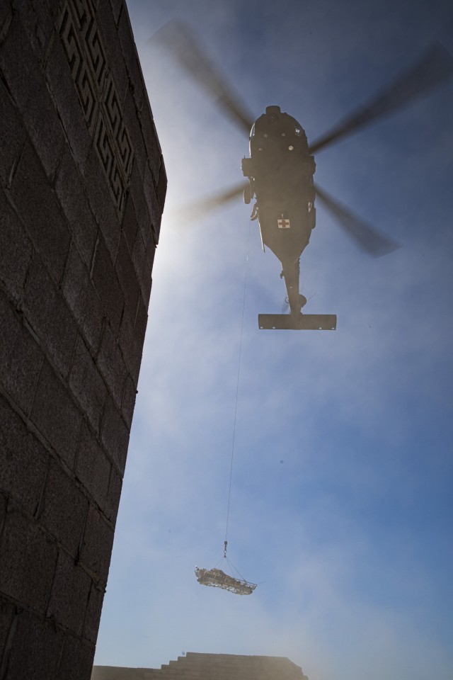 U.S. Army Soldiers assigned to the 82nd Airborne Division conduct a medical evacuation, while experimenting with a Load Stability System – Litter Attachment (LSS-LA) on Yuma Proving Ground, Arizona, Oct. 28, 2021, during Project Convergence 2021. 

The LSS-LA uses a fan system to help stabilize the litter, so that the person being evacuated does not spin while being pulled up to a helicopter. (U.S. Army photo by Scott Childress/U.S. Army Aeromedical Research Laboratory)
