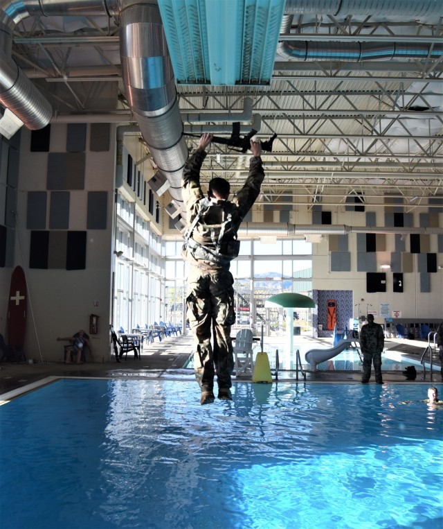 A Soldier from 2nd Space Company, 1st Space Battalion, 1st Space Brigade, U.S. Army Space and Missile Defense Command, leaps off a three-meter diving board as part of the company’s annual combat water survival training, which familiarizes Soldiers in deep water in case of emergency, at Fort Carson, Colorado, Oct. 29, 2021. (U.S. Army photo by Sgt. 1st Class Aaron Rognstad/RELEASED)