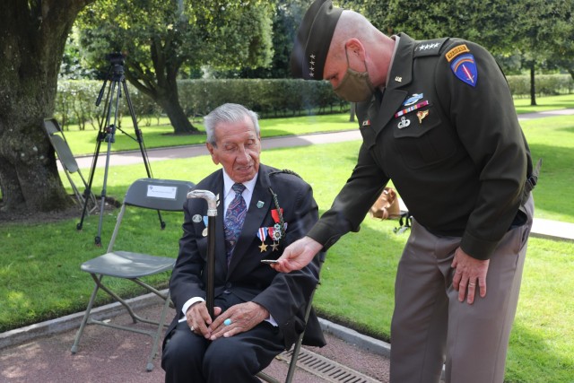 U.S. Army Europe and Africa Commanding General, Gen. Christopher Cavoli presents War World II Veteran, Charles Shay with a U.S. Army Europe and Africa command coin at the Normandy American Cemetery and Memorial during the International D-Day Ceremony on June 6, 2021, in Normandy France.  The Cemetery honors American troops who died in Europe during World War II. (U.S. Army photo by Sgt. Joseph McDonald)