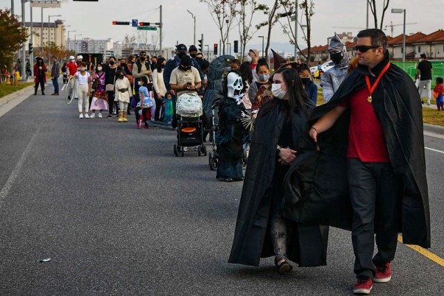 Camp Humphreys community members line Marne Avenue during the installation's annual Trunk or Treat extravaganza Oct. 30, 2021. Volunteers decorated their trunks with different themes and dressed in matching costumes to hand out candy to families. (U.S. Army photo by Spc. Brooke Davis)