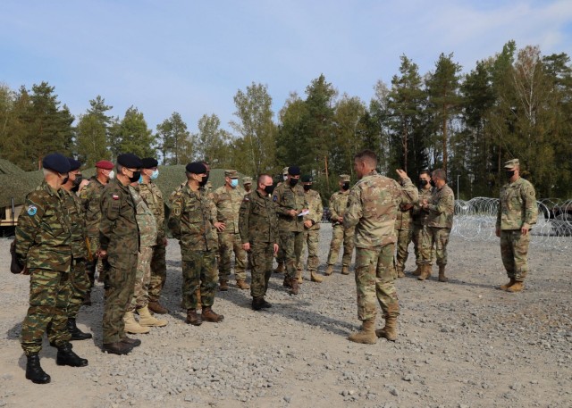 GRAFENWOEHR, Germany - Senior leaders from NATO and U.S. militaries, attend the V Corps distinguished visitors day during Warfighter 22-1, in Grafenwoehr, Germany, Oct. 2. V Corps hosted a DV Day, which included a tour of V Corps' main command post for Warfighter 22-1, to discuss the future of V Corps and bolster relationships with allies and partner forces. The WFX 22-1 is V Corps' final certifying exercise in becoming the U.S. Army's fourth corps headquarters and America's forward deployed corps in Europe.  (U.S. Army photo by Pvt. Gabriella Sullivan/released)