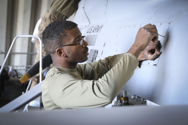 U.S. Army Spc. Ashton Etheredge, an MQ-1C Gray Eagle maintainer with Fox Company, 1st Attack Reconnaissance Battalion, 1st Combat Aviation Brigade, prepares to remove the avionics bay panel after a flight mission during Maneuver Warfare Exercise...