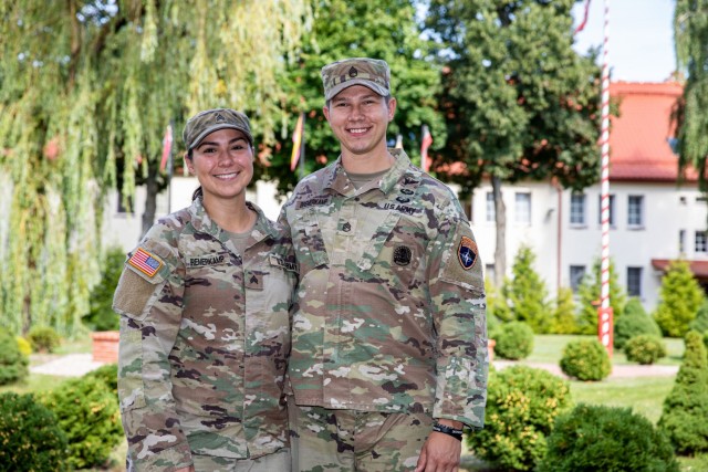 From left, U.S. Army National Guard Sgt. Monica Bremerkamp and Staff Sgt. Matthew Bremerkamp pose for a photo at Bemowo Piskie Training Area, Poland, August 15, 2021. The Bremerkamps are one of many dual-military married couples at BPTA, and the National Guard ensured they stayed together during this rotation. (U.S. Army photo by Spc. Osvaldo Fuentes)