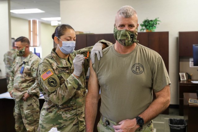 Maj. Kelly Guerra, First Army senior physician assistant, administers an influenza vaccination to Command Sgt. Maj. John McDwyer, First Army’s senior enlisted Soldier.  