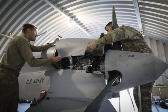 U.S. Army 1st Sgt. David Garcia, right, Fox Company’s first sergeant, and U.S. Army Spc. Nathan Trevino, an MQ-1C Gray Eagle maintainer with Fox Company, 1st Attack Reconnaissance Battalion, 1st Combat Aviation Brigade, remove an aft engine cowl...