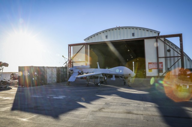 U.S. Army Soldiers with Fox Company, 1st Attack Reconnaissance Battalion, 1st Combat Aviation Brigade, dolly in an MQ-1C Gray Eagle into an aircraft hangar after a flight mission during the U.S. Marine Corps-led joint exercise, Maneuver Warfare...