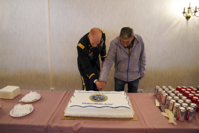 USAG Bavaria Garrison Commander Col. Christopher Danbeck and Mr. Gonzales, the awardee being recognized for 45 years of service, cut the cake in the traditional celebration at the end of the Length in Service award ceremony at the Tower View Conference Center in Tower Barracks on Oct. 15, 2021. (U.S. Army Photo by Julian Temblador / USAG Bavaria)