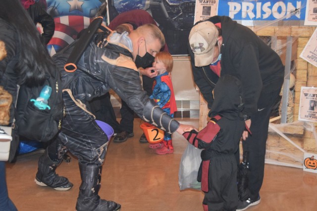 Col. Todd Allison, garrison commander, U.S. Army Garrison Rock Island Arsenal, drops a piece of candy in the bag of a participant in the garrison&#39;s Boo on the Rock / Trunk or Treat celebration held Oct. 28 in Heritage Hall and the Lock &...