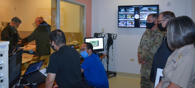 As a simulation is underway, Navy Capt. Tracy Farrill, far right, assistant director for health care administration; Dr. Brian Lein, Defense Health Agency assistant director; and Army Col. Martin Doperak, commander of Tripler Army Medical Center, receive a tour of the Medical Simulation Center during a recent visit at Tripler.
