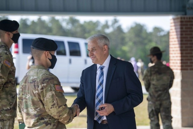 Christopher Lowman, the senior official performing the duties of the undersecretary of the Army, gives a coin to a  Soldier at Fort Jackson, South Carolina on April 29, 2021. Lowman discussed the importance of recruiting civilian talent in STEM career fields during a House Appropriations Committee hearing in October. 