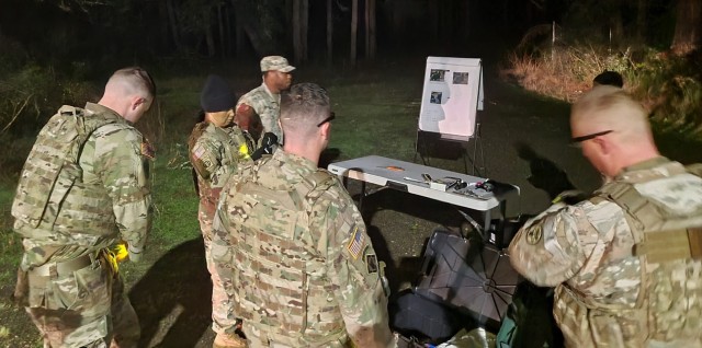 Contestants in the Regional Health Command-Pacific Best Medic Competition receive a route briefing before their 12-mile road march, 2 a.m., Nov. 2. The road march, with rucksacks weighing more than 40 pounds, was the final event in the competition. 