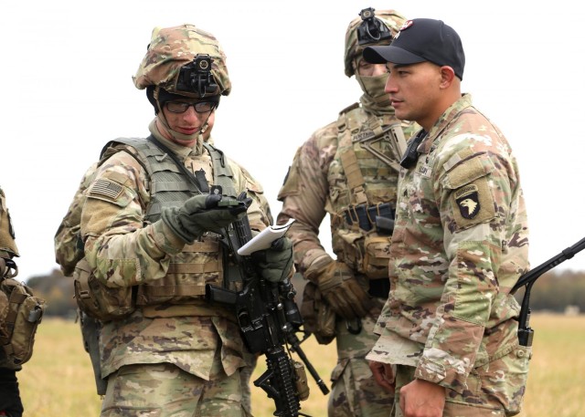 Private 1st Class Tanner Chaney an Infantryman with A Co., 1st Battalion, 327th Infantry Regiment, 1st Infantry Brigade Combat Team, 101st Airborne Division (Air Assault), shoots an azimuth with his compass to determine the landing zone as Sgt. Brandon Quintalla, an Instructor with The Sabaluski Air Assault School, supervises during training as part of Lethal Eagle, November 3, 2021, at Corregidor Drop Zone, Fort Campbell, KY.
