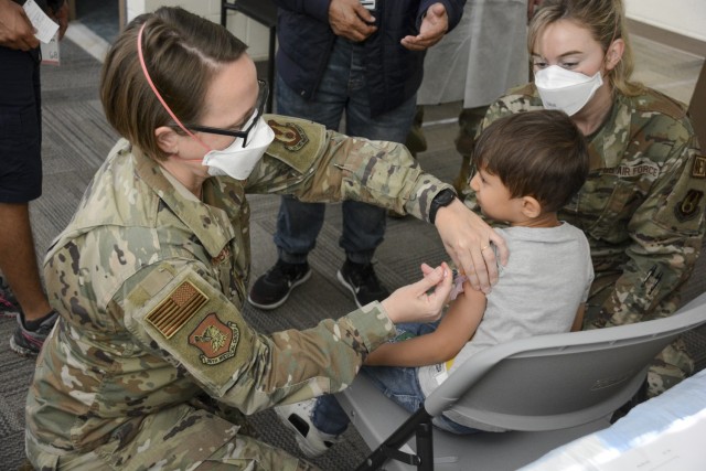 Capt. Jennifer Swanberg, 321st Air Expeditionary Group emergency room nurse, administers a vaccine to an Afghan child as part of Task Force Eagle’s support of Operation Allies Welcome at Fort Lee, Virginia. The Department of Defense, through U.S. Northern Command and in support of the Department of Homeland Security, is providing transportation, temporary housing, medical screening and general support for Afghan evacuees at several installations across the country. Upon completion of the special applicant visa process, they are being resettled into civilian communities throughout the U.S.  (U.S. Army photo by Brian Stevens / Fort Lee Garrison Public Affairs )