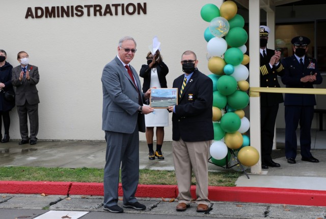 Mr. Lee Seeba, Chief of Construction for the U.S. Army Corps of Engineers - Japan District, presents Jason Sheedy, Principal of Robert D. Edgren Middle High School, with a plaque signifying the extraordinary measures that USACE overcame to get the school opened. The full-color plaque is dedicated to the faculty and students of the school.