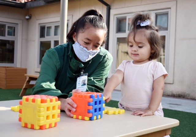 Quincee Burks, a child care provider, plays with blocks with Catalina Hardy, 18 months, at the Child Development Center at Ord Military Community, Nov. 4.