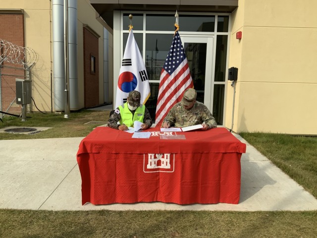 Col. Pyo In Tae (left), Chief, Program Management Team, ROK Design and Construction Agent, and Col. Garrett Cottrell (right), Deputy Commanding Officer - Transformation, U.S. Army Corps of Engineers Far East District, sign the Acceptance Release Letter for C4I090, which will support security operations for the Battle Command Training Center at USAG Humphreys, Republic of Korea, Nov. 5. This event signifies a major project milestone for C4I090 and demonstrates the strength of the US-ROK alliance.