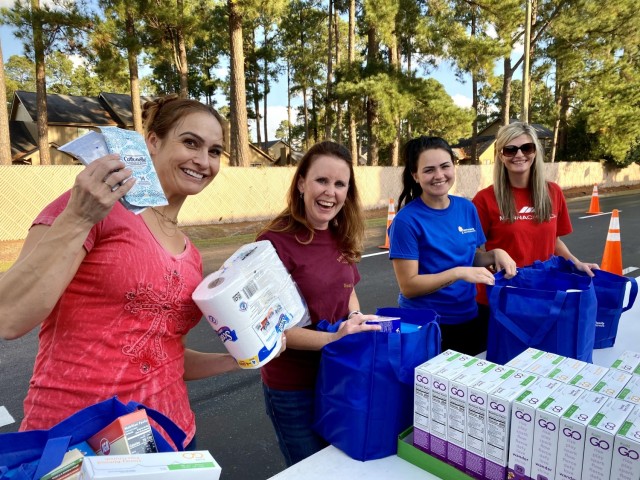 Volunteers pose for a photo while packing bags with food to be distributed during the Military Family Advisory Network’s 1 million meal challenge at Manna Church, Oct. 23, 2021.  (U.S. Army Reserve photo by Sgt. 1st Class Javier Orona)