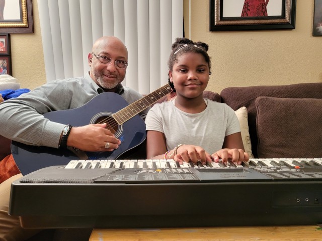 Ramon Turner Sr., security specialist, 1st Theater Sustainment Command, and daughter, Angel, practice playing &#34;Twinkle, Twinkle, Little Star&#34; in their home at Fort Knox, Kentucky, October 28, 2021. They have also learned how to play &#34;Happy Birthday&#34; together.