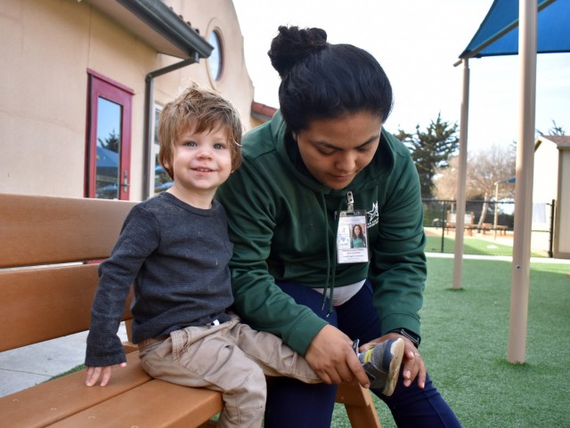 Gabriela Lazaro, lead teacher in a toddler room, helps Parker Caroland, 2, with his shoe at the Child Development Center at Ord Military Community, Nov. 4.