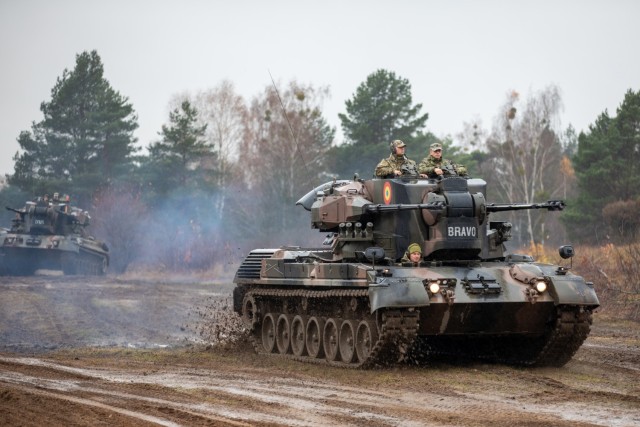 Romanian Land Forces soldiers from Iron Cheetahs move a Gepard to a new battle position during Rifle Forge at Bemowo Piskie Training Area, Poland, Nov. 3, 2021. Rifle Forge was a culminating combined arms live-fire exercise that involves allies from Battle Group Poland. Two new contingent forces joined the Battle Group for this defensive scenario; the Romanian Land Forces Iron Cheetahs and British Army Black Horse Troop. (U.S. Army photo by Pfc. Jacob Bradford)