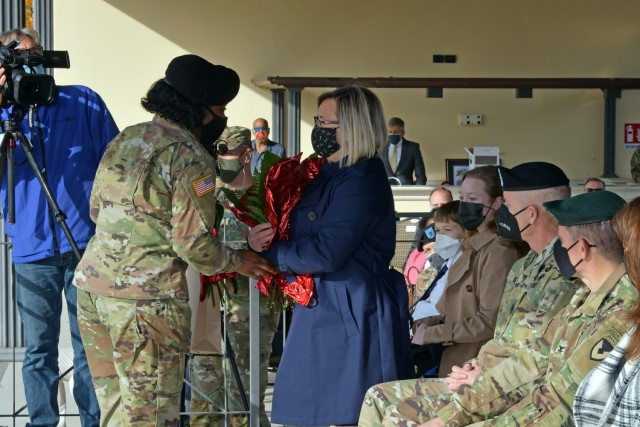 Mrs. Tonya Ann Hirata, wife to Command Sgt. Maj. Billy S. Vetten, outgoing command Sgt. Maj. of U.S. Army Garrison Italy, is awarded red flowers during change of responsibility ceremony under Covid-19 prevention condition at Caserma Ederle, Vicenza, Italy Nov. 10, 2021. (U.S. Army Photos by Davide Dalla Massara)