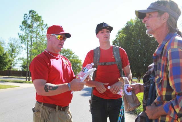 Joshua Summers and Christopher Jordan give a homeless man a bag of hygiene products and food vouchers during a former I Count point in time survey.