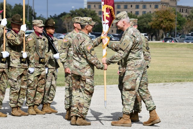 Col. Marc Welde, incoming Commander, 32nd Medical Brigade accepts the unit colors from Maj. Gen. Dennis LeMaster during the Change of Command Ceremony. 