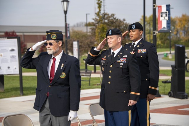 Veterans Day speakers ret. Maj. Edwin Miller, Lt. Col. Brad Fausnaugh, and Recruiting Commander Capt. Gaskins salute during Star-Spangled Banner at an event honoring 18 new Army Soldiers, Nov. 11, US Army Heritage & Education Center, Carlisle Pa.