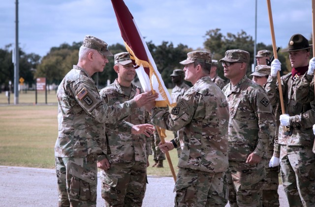 Col. Wesley Anderson, the outgoing 32d Medical Brigade Commander, passes the unit colors to Maj. Gen. Dennis LeMaster, as he relinquishes command.