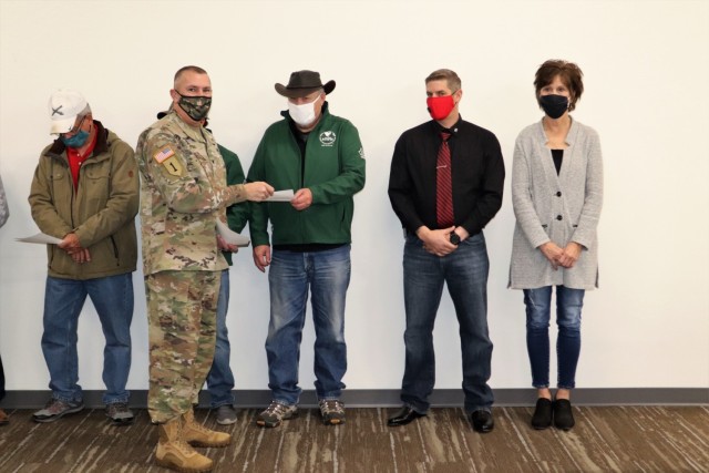 Members of the Fort McCoy workforce are shown being recognized for excellence Nov. 4, 2021, in the Installation Emergency Operations Center by Deputy Garrison Commander Lt. Col. Chad Maynard and Fort McCoy Garrison Commander Col. Michael Poss....