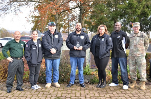 Members of the U.S. Army Garrison Rheinland-Pfalz command team and Baumholder Youth Sports and Fitness Program pose for a photo with the “Excellence in Youth Sports” award at the Baumholder memorial Nov. 10. Pictured from the left is, Jae J. Kim, Baumholder deputy garrison manager; Andhia Campos, Randy Ault, Marcel Fisher, Whitney Clemmons, and Henry Wilkerson, CYS staff members; and Lt. Col. Jeremy A. McHugh, acting garrison commander. The Child Youth Services program earned this accolade from the National Alliance of Youth Sports recognizing them as a top-five youth sports program in the United States.