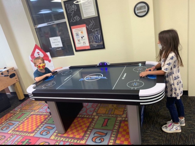 Kids apart of Youth Services at YPG enjoy the game of air hockey after returning to in-person learning back in October of 2020.