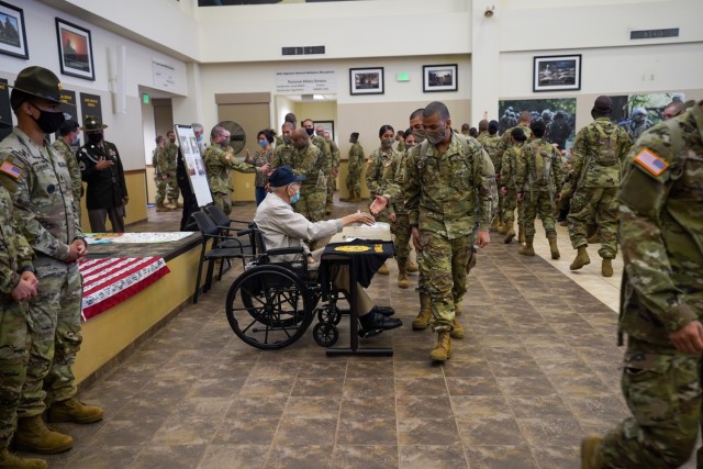 Trainees at the 95th Adjutant Battalion (Reception) line up to thank retired Lt. Col. James Thompson for her service Nov. 8, 2021, at Vessey Hall on Fort Sill, Oklahoma. Everyone who had been vaccinated and who wore a face mask were invited to honor Thompson.