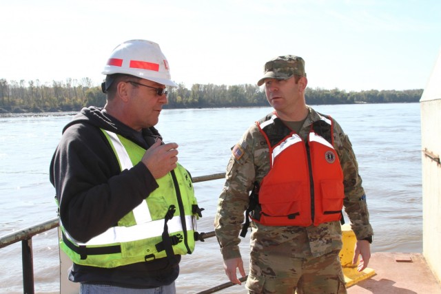 Jake Bernhardt, Chief of Physical Support for the Dredge Goetz, explains the operations of the dredge to Maj. John Chambers, deputy commander for the Kansas City District, on the bow of the Dredge Goetz near St. Charles, Mo. on the Missouri River...