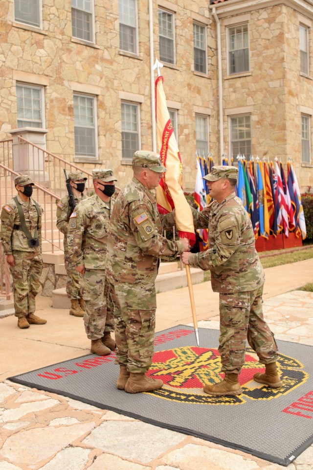 Col. Rhett Taylor, Fort Sill garrison commander, hands the guidon to Command Sgt. Maj. William Taylor, garrison command sergeant major in an Assumption of Responsibility Ceremony Nov. 10, 2021 in front of Fort Sill’s Taylor Hall.