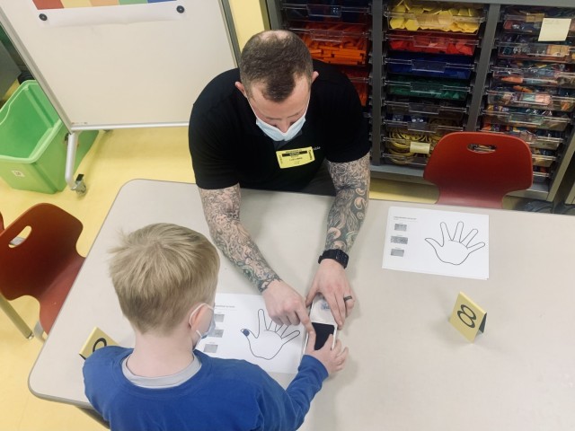 Scott Luellman, investigator with the U.S. Army Garrison Wiesbaden Military Police Investigations division engages with students at Wiesbaden Elementary during a fingerprinting activity on Nov. 16, 2021.