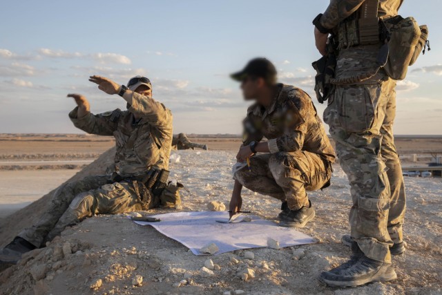 A Coalition Joint Terminal Attack Controller (left) explains aircraft movements to an Iraqi Tactical Attack controller (center) near Al Asad Air Base, Iraq, Oct. 20, 2021.  The two air controllers participated in Exercise Phoenix Fires to allow ITACs to better hone their skills.  (U.S. Army Photo by Staff Sgt. Jose A. Torres, Jr.)