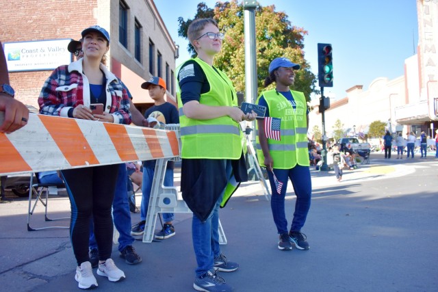 Marine Corps. Pfc. Arizona Keithley, left, in yellow vest, assigned to the Marine Corps Detachment, and Army Spc. Tiffaney Mitchell, assigned to the 229th Military Intelligence Battalion, staff a traffic barricade during the 11th Annual Veterans Day Parade in Salinas, Calif., Nov. 11.