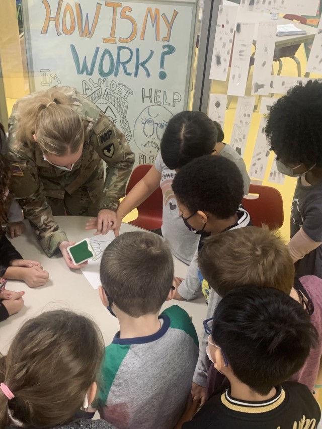 Staff Sgt. Anastasiya Jones, community outreach coordinator with the U.S. Army Garrison Wiesbaden military police engages third graders at Wiesbaden Elementary in a fingerprinting activity on Nov. 16, 2021.