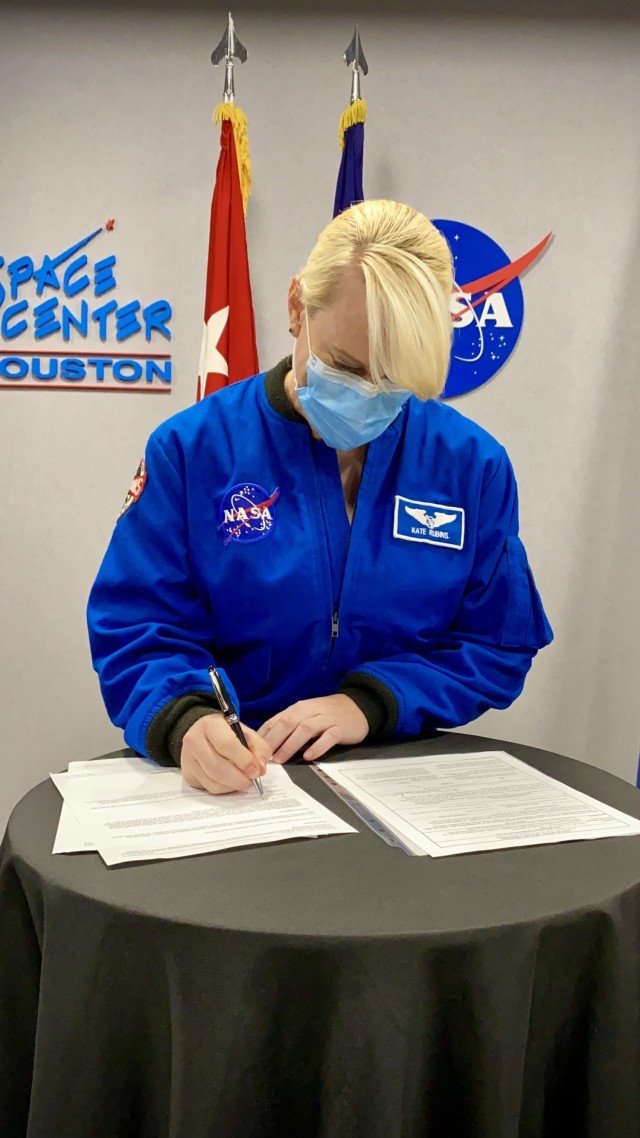 Dr. Kate Rubins, a NASA astronaut, signs her contract after being commissioned to the rank of major in the United States Army Reserve.  The ceremony was conducted at NASA’s Johnson Space Center in Houston, Nov. 2, 2021. (U.S. Army Reserve photo by Sgt. 1st Class Javier Orona)