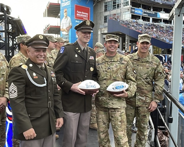 Blanchfield Army Community Hospital command team, Col. Vincent B. Myers and Command Sgt. Maj. Daniel Santiago, and 101st Combat Aviation Brigade Commander Col. Travis M. Habhab and Chief Warrant Officer 5 Steve Dermer, 101st CAB command chief warrant officer, accept a commemorative game ball on behalf of their Soldiers who participated in pregame ceremonies before the Tennessee Titans and New Orleans Saints football game at Nissan Stadium, Nov. 14. Soldiers from Blanchfield Army Community Hospital, Soldier Recovery Unit, Dental Activity, Public Health Activity and 531st Hospital Center unfurled a U.S. flag and served as the honor guard during the national anthem. Soldiers from the 101st Combat Aviation Brigade provided a flyover representing the division in the air.