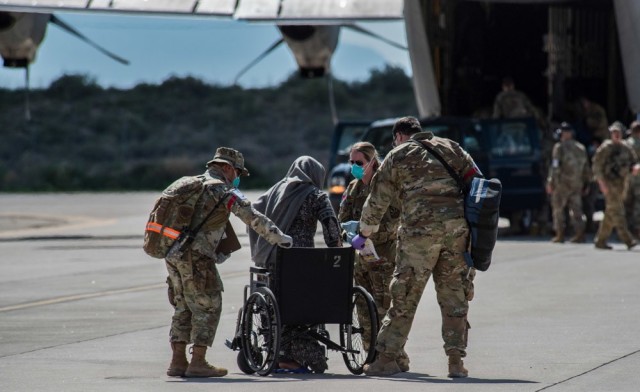 Airmen from Task Force-Holloman assist an Afghan evacuee into a wheelchair on the ramp at Holloman Air Force Base, New Mexico, Aug. 31, 2021. The Department of Defense, through U.S. Northern Command, and in support of the Department of State and...