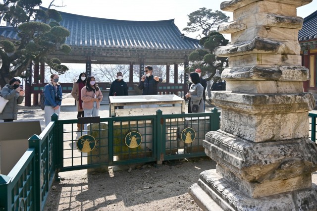 Tour participants gather at a statue in the Silleuksa Temple in Yeoju, South Korea, Nov. 15, 2021, while a tour guide explains the significance of the temple. The group was part of a cultural event organized by the Korea-America Friendship Society and included military members, their Families and other members of the community. (Photo by Monica K. Guthrie)