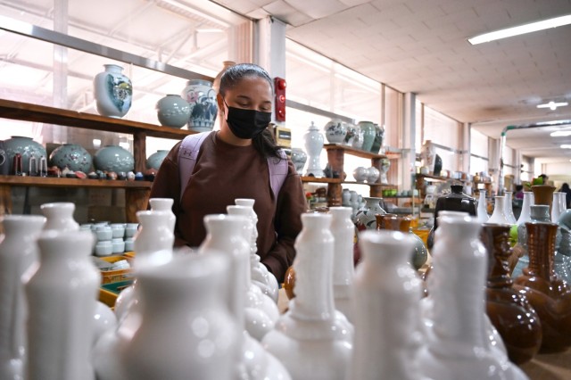Pvt. Danielle Oxendine, from 3-2 General Support Aviation Battalion, 2nd Combat Aviation Brigade, looks at vases during a ceramics cultural trip Nov. 15, 2021, in Yeoju, South Korea. (Photo by Monica K. Guthrie)