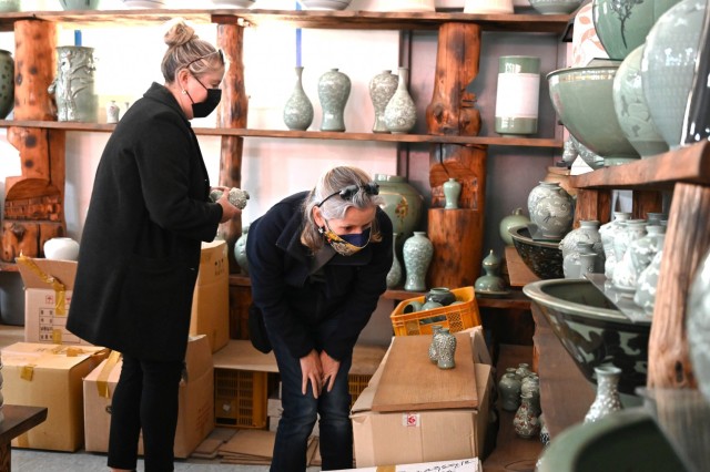 U.S. military family members browse a warehouse of pottery before creating their own ceramics Nov. 15, 2021 during a ceramics cultural trip in Yeoju, South Korea. The pottery was available for purchase and included items ranging from miniature pots with lids to two-foot vases and planters. (Photo by Monica K. Guthrie)