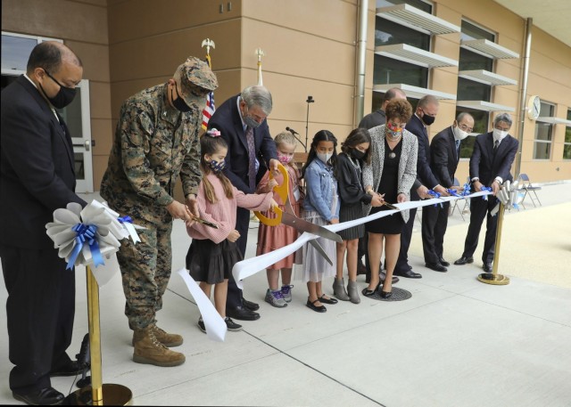 Japan Engineer District, U.S. Army Corps of Engineers employees cut the ribbon during an official ribbon-cutting ceremony for Edward C. Killin Elementary Nov. 10, 2021 on Camp Foster, Okinawa, Japan. The district joined representatives from Department of Defense Education Activity, Marine Corps Installations Pacific, and host-nation contractors to commemorate state of the art learning spaces for DoD students in the region. (U.S. Army Corps of Engineers photo by Honey Nixon)