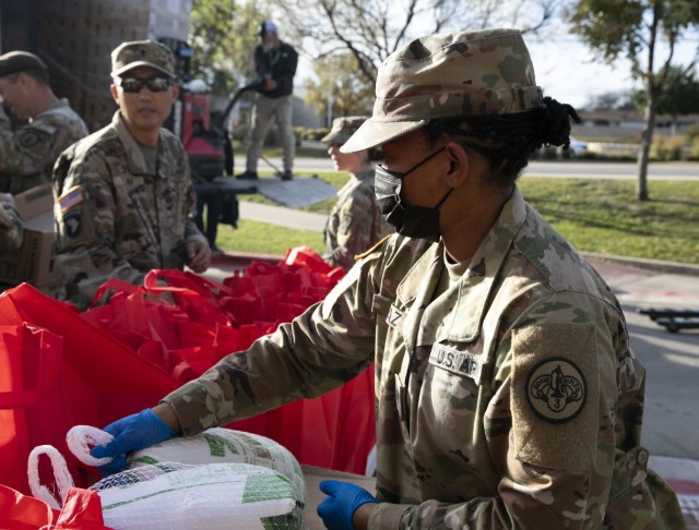 Spc. Chelsea Diaz, 3d Cavalry Regiment, puts turkeys into bags to give them to Fort Hood families, Fort Hood, Texas, Nov. 17, 2021. Soldiers are nominated by their units and receive a turkey, side dishes, and desert to celebrate Thanksgiving with their loved ones and family members. (U.S. Army photo by Sgt. Melissa N. Lessard)